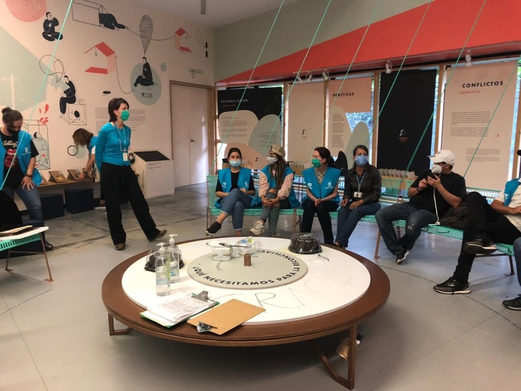 Masked staff and visitors standing in a museum space