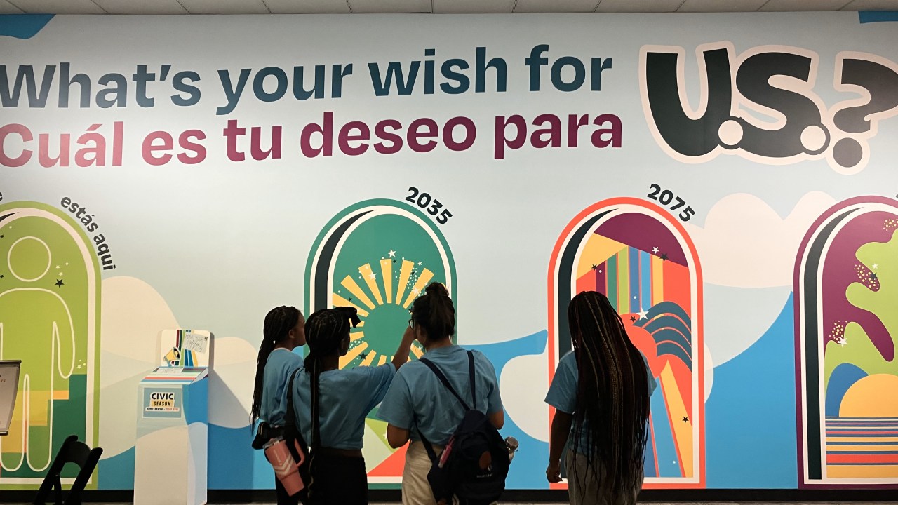 Brightly colored wall with the words "What's your wish for U.S.? " in English and Spanish.