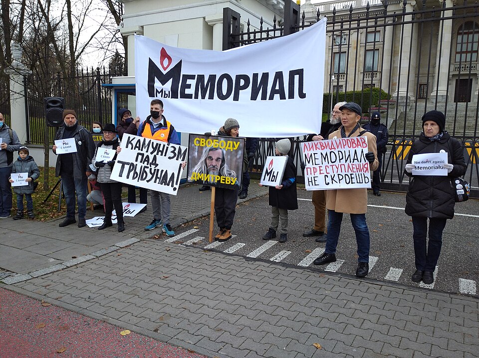 Protestors outside a building holding signs in Russian.