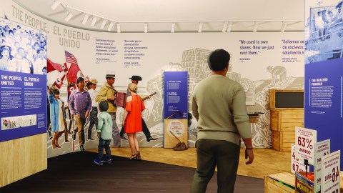 A design rendering shows the graphic program for the César E. Chávez National Monument. A sepia-toned graphic mural of farmworkers in a field wraps around the back of the gallery space from floor to ceiling. Color photographic images of people marching and holding flags overlay the mural. Blue and white didactic panels, some with photographs on top, also fill the space. Three figures, two adults and one child, give a sense of the scale of the gallery.