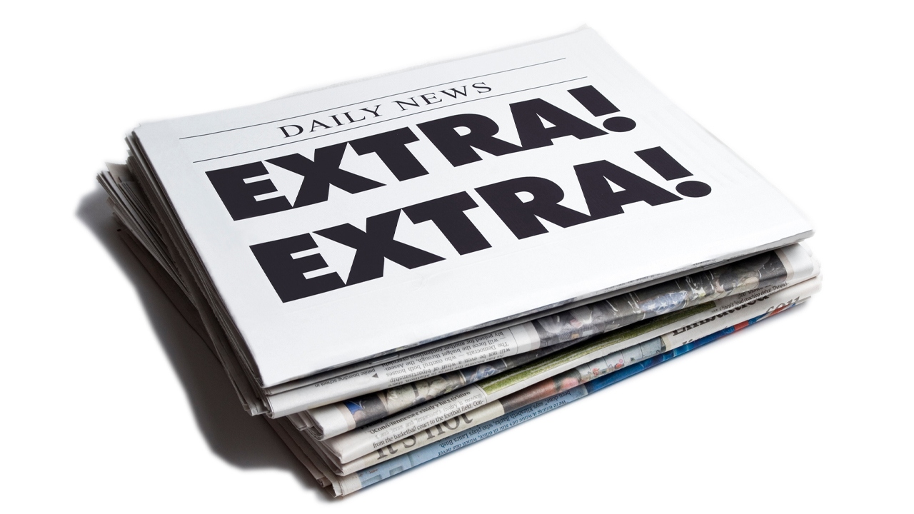 A stack of newspapers with the headline "Extra! Extra!" written on the cover