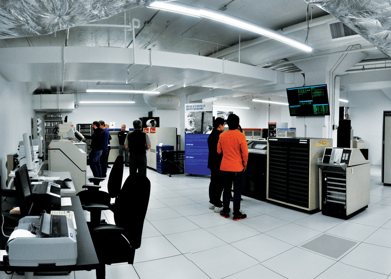 People standing in a room with computer equipment