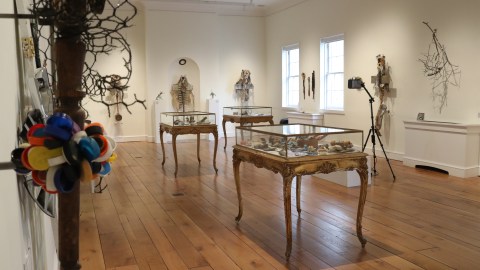 One of the rooms in The Future of Here exhibit with artifacts created from found objects in cases and flanking the walls.