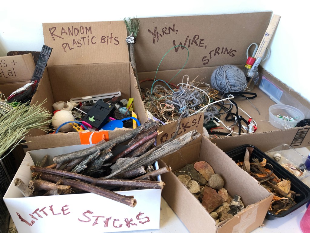 Odds and ends organized on a table for visitors to create their own artifacts of the future.