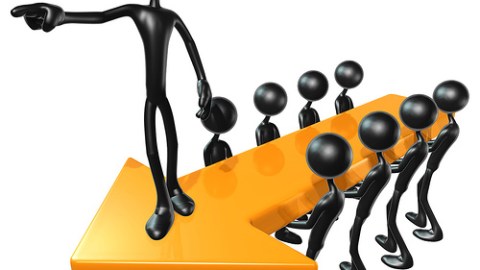 Cartoon of multiple people holding an arrow with a figure on top pointing in the same direction.