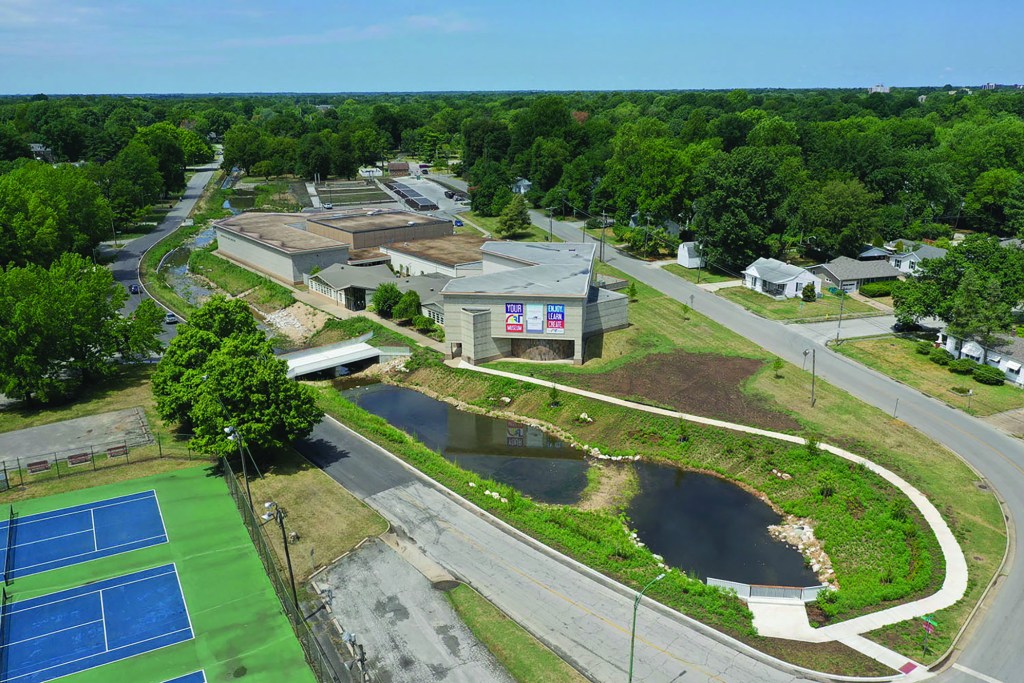 Bird's eye view of the Springfield Art Museum and surrounding area, with grass, a creek, and tennis courts.