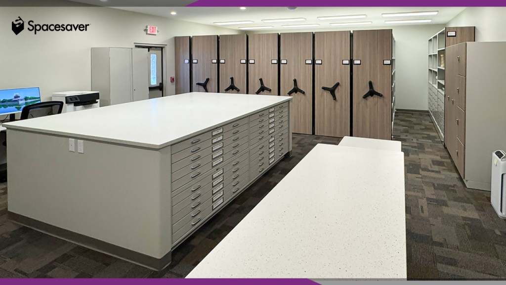 A storage room with flat file storage and compactor storage units in the background.