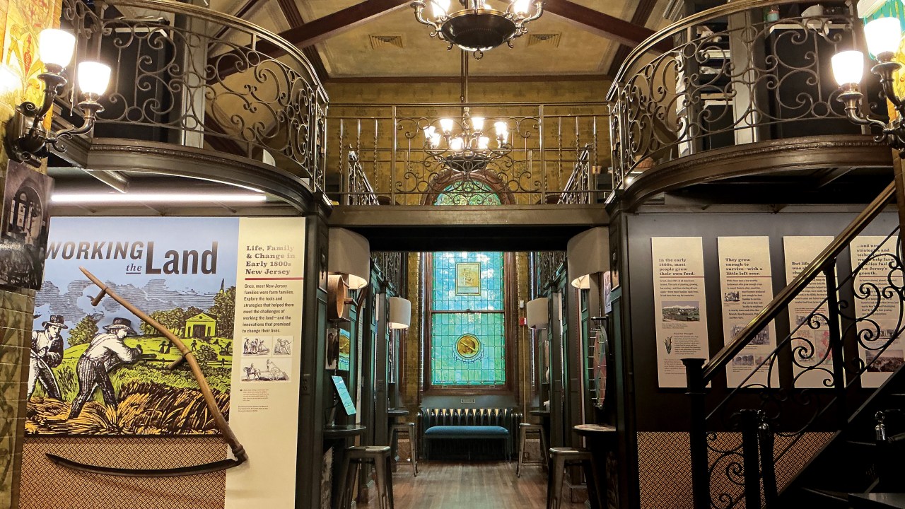 Room with chandelier, wooden floors, and stained glass windows.