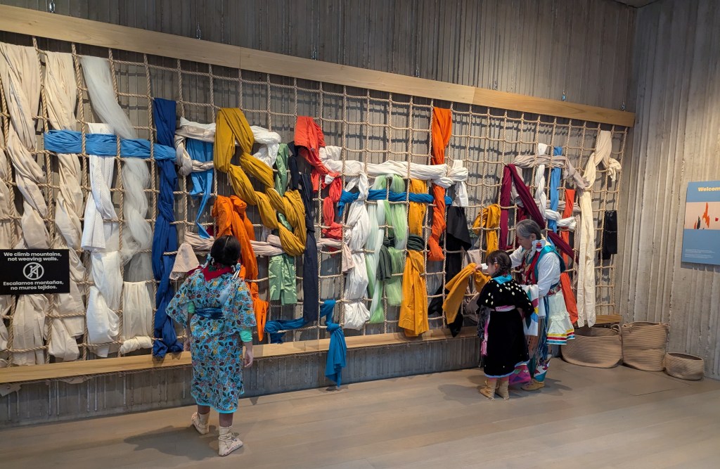 Young people with their grandmother in front of an interactive exhibit.
