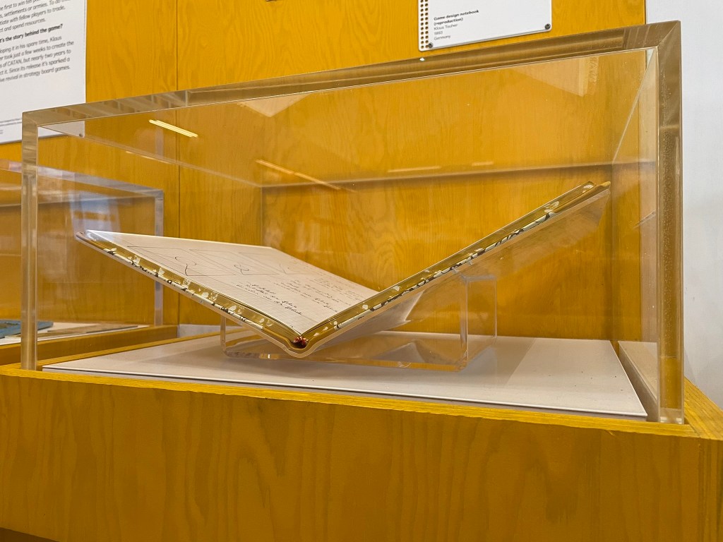 An exhibition acrylic hood displaying an open book, resting on an acrylic book cradle mount.