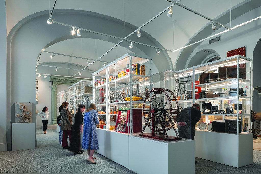 Visitors viewing collection objects inside display cases.