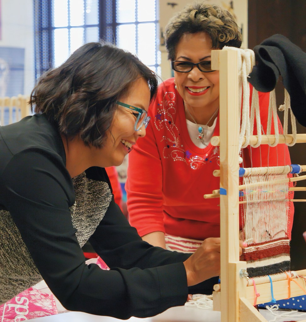 Two women weaving.