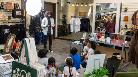 Adult explaining to a group of children sitting on the floor