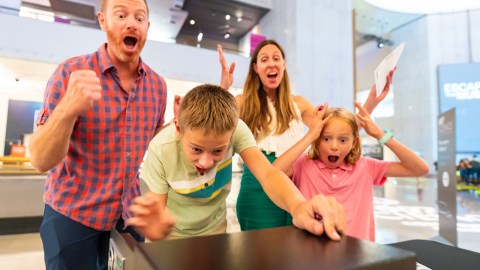A family with two children are screaming with surprise inside a museum.