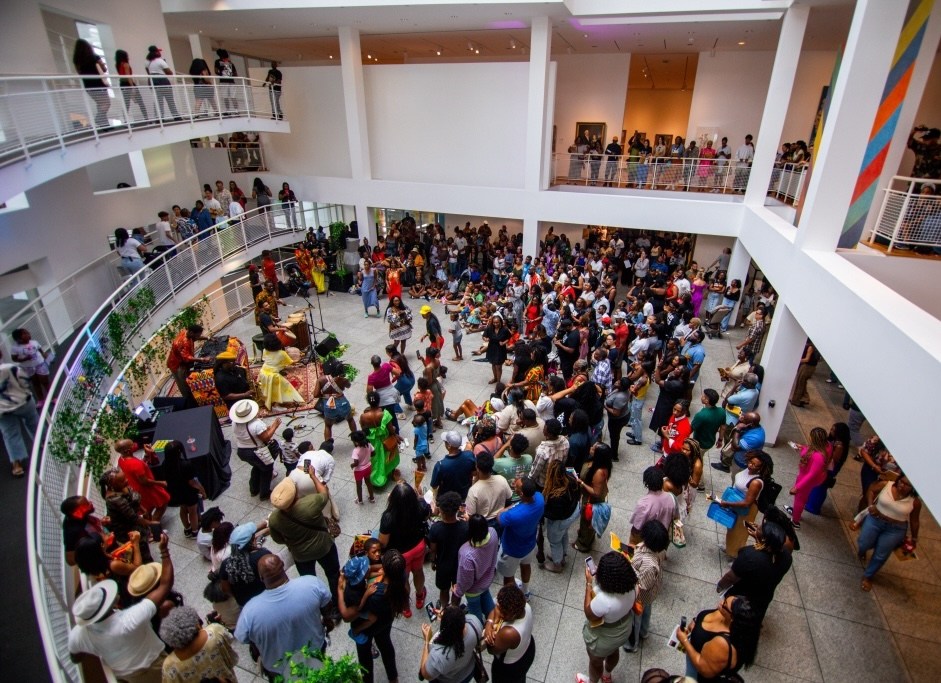 A crowd of people gathered in an atrium watching a performance