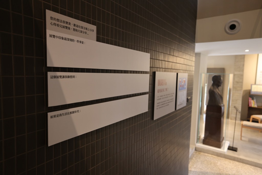A quiet reflection station with blank horizontal response strips mounted on a wall invites visitors to leave written reflections.