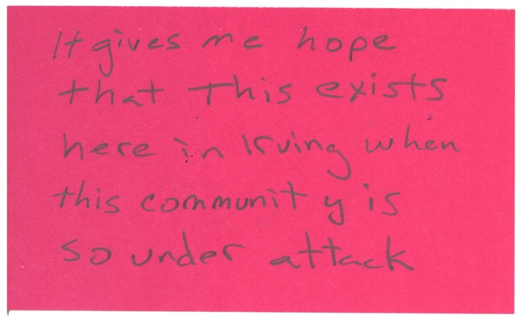A pink index card with handwriting on it that reads: “it gives me hope that this exists here in Irving when this community is so under attack.”